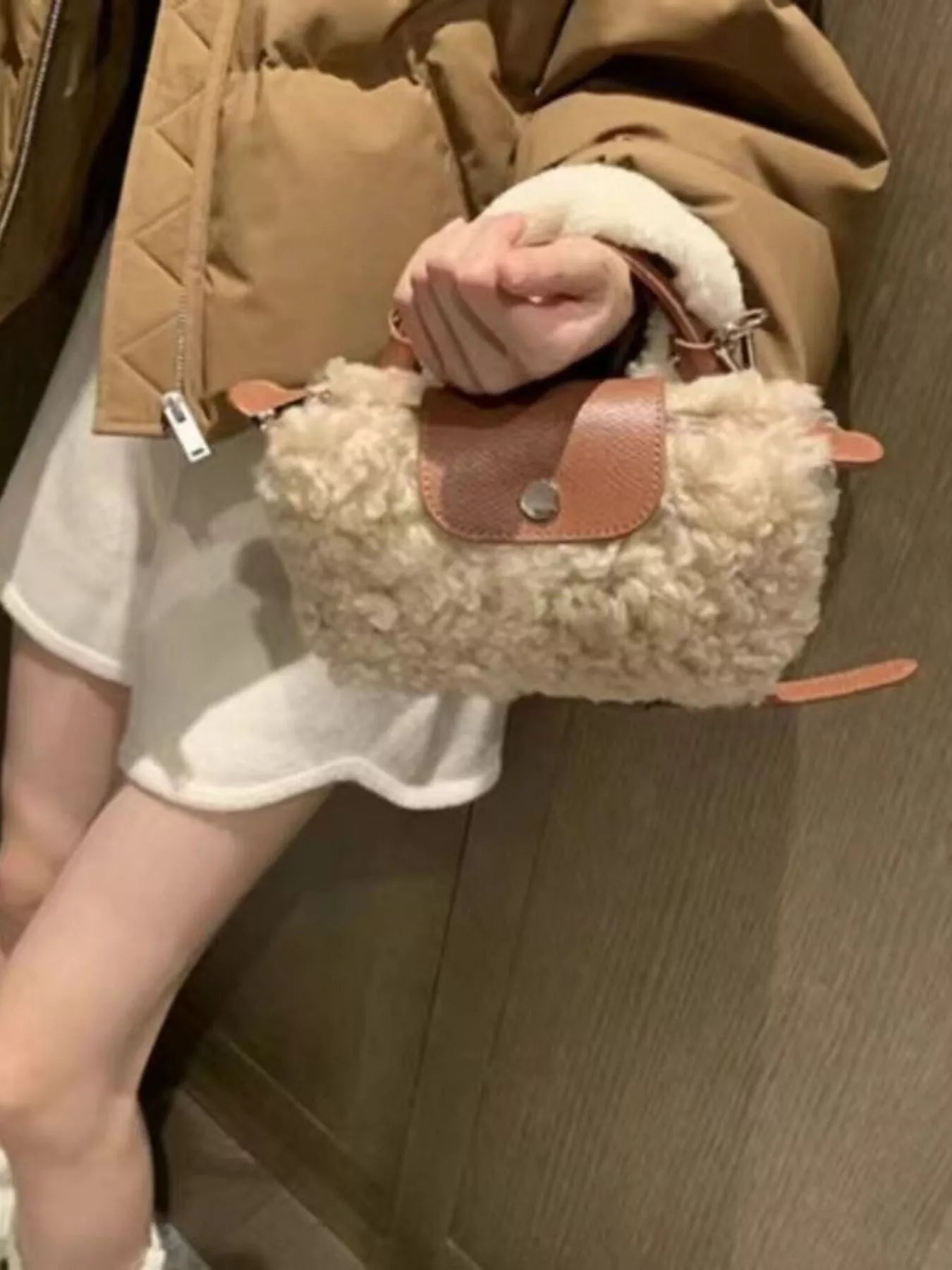 Textured mini crossbody bag in khaki with brown leather flap and silver button closure.