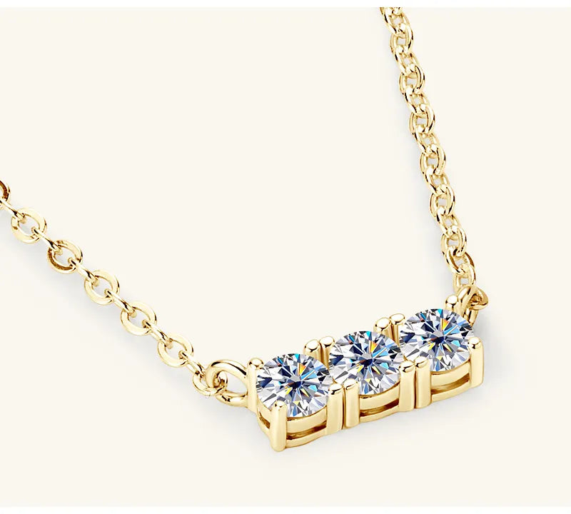 Gold bar necklace with three round moissanite stones on a delicate chain.