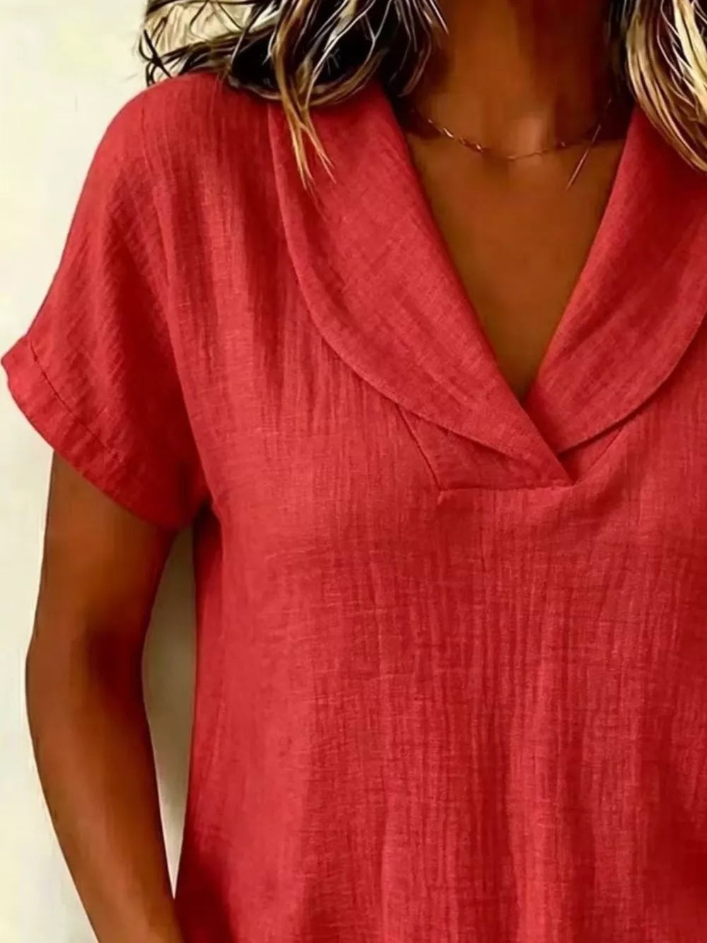 Red textured blouse with short sleeves and a V-neck collar.