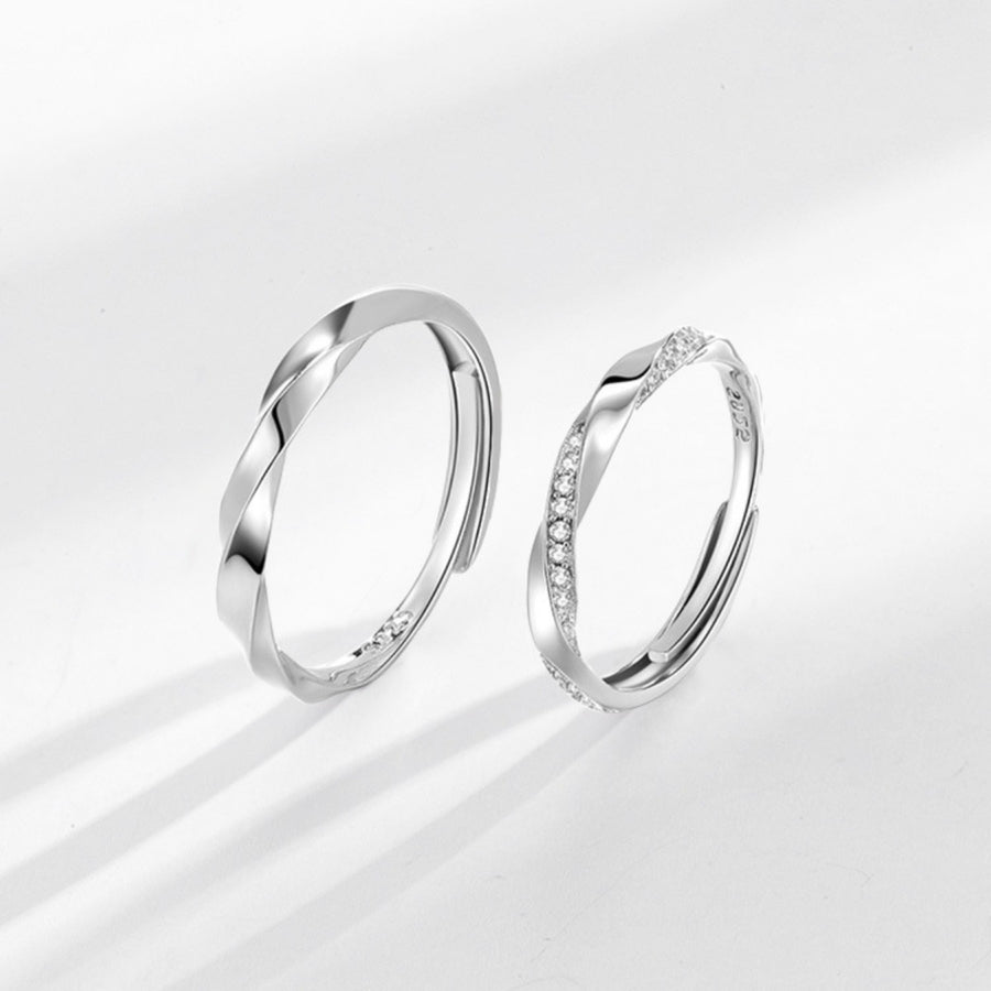 Adjustable sterling silver rings, one plain twisted band, one with pave zircon accents.