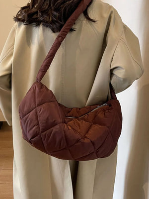 Quilted crossbody bag in brown with a puffy, diamond-stitched design and a twisted strap.