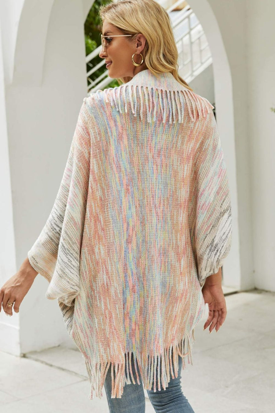 Textured stripe fringe cape with pastel multicolor yarn and fringe detail.