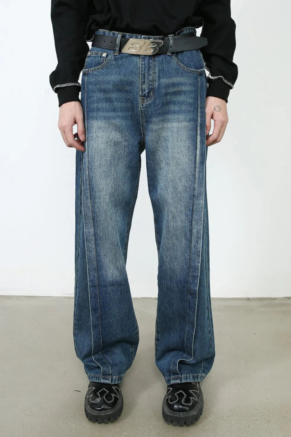 Medium wash denim wide leg jeans with vertical seams and a relaxed fit.