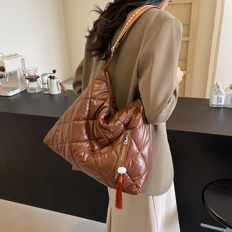 Brown diamond quilt padded shoulder bag with zipper and tassel detail.