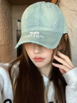 Distressed light blue baseball cap with white text and frayed brim.