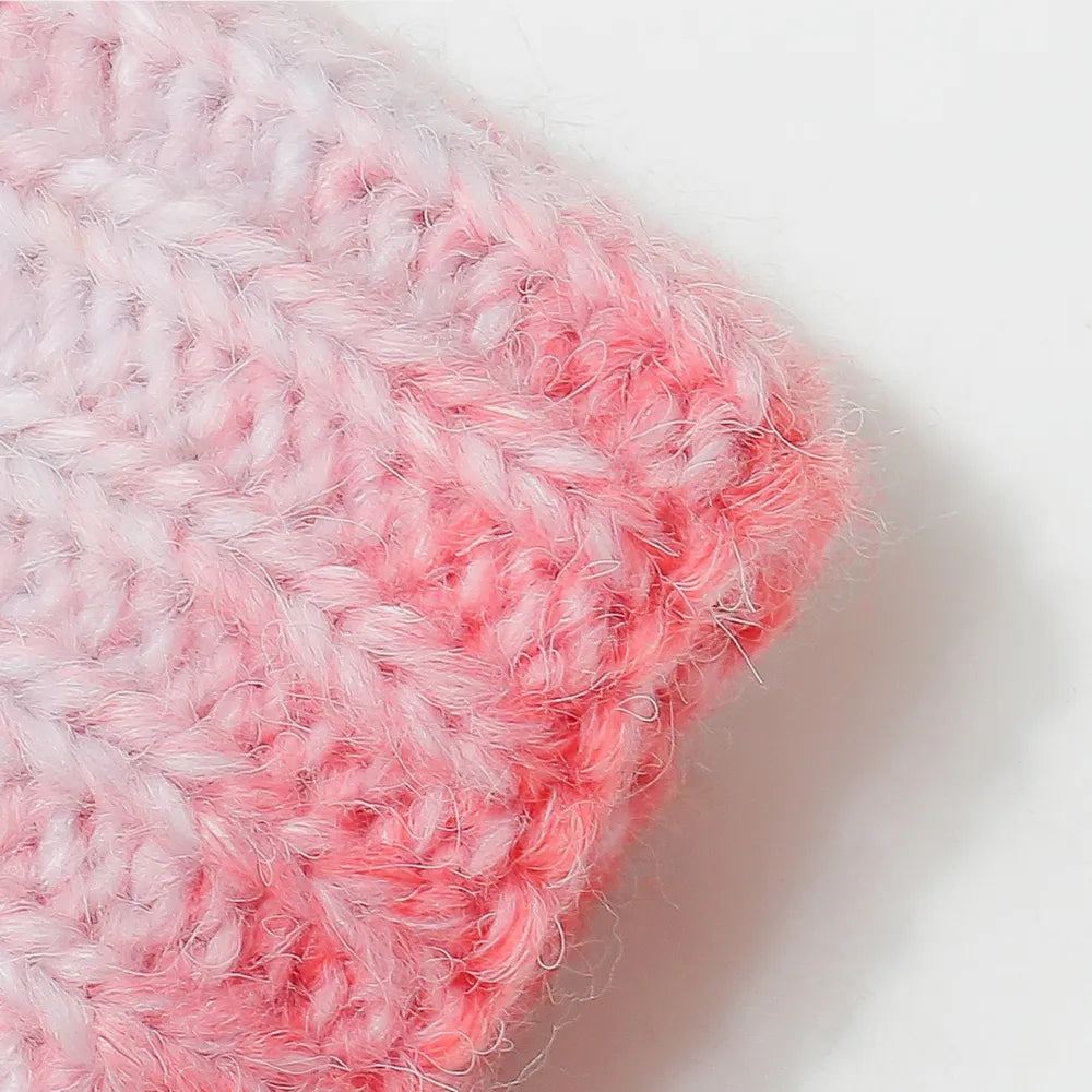Textured ombre knit beanie in pink and white with a fuzzy finish.