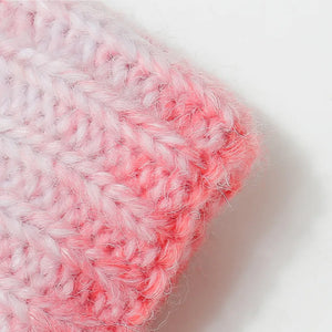 Textured ombre knit beanie in pink and white with a fuzzy finish.