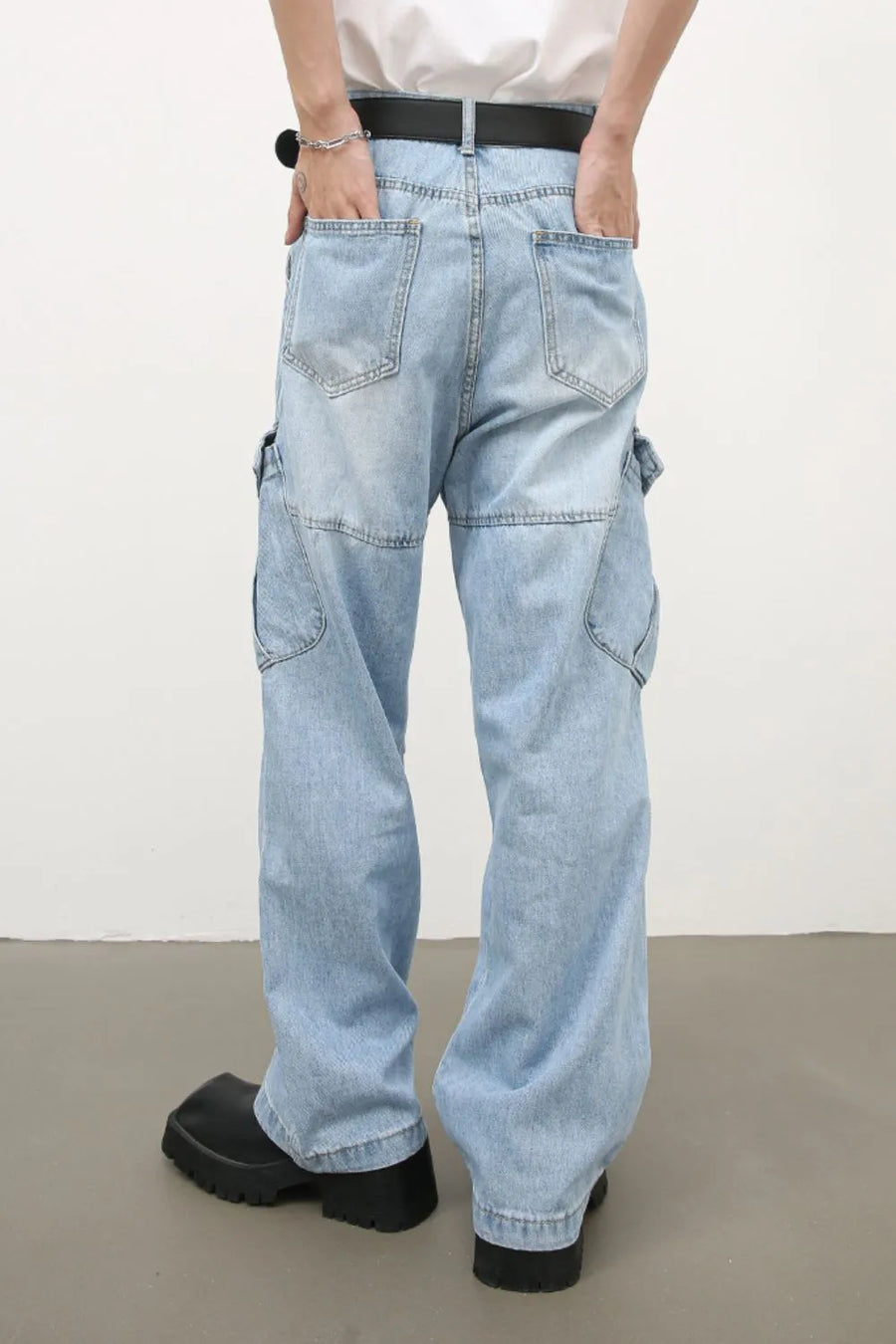 Baggy light wash denim cargo pants with utility pockets and a relaxed fit.