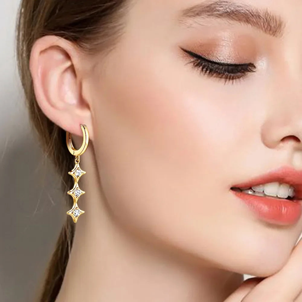 Gold hoop earrings with three cascading star-shaped moissanite charms.