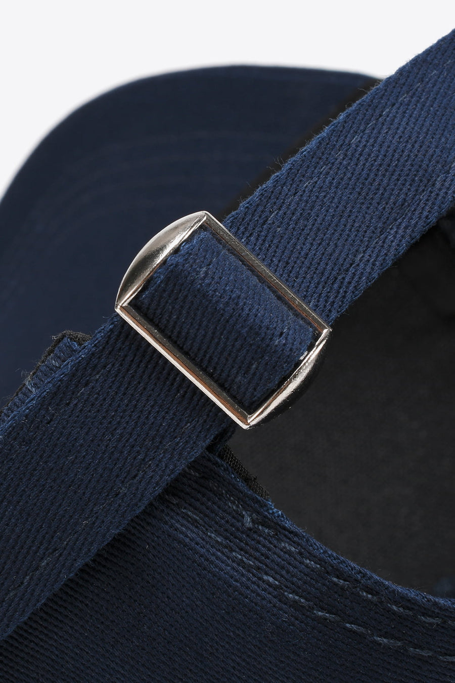 Navy cotton twill baseball cap with adjustable strap and silver buckle detail.