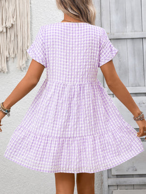 Plaid V-neck mini dress in light purple with short sleeves and tiered skirt.