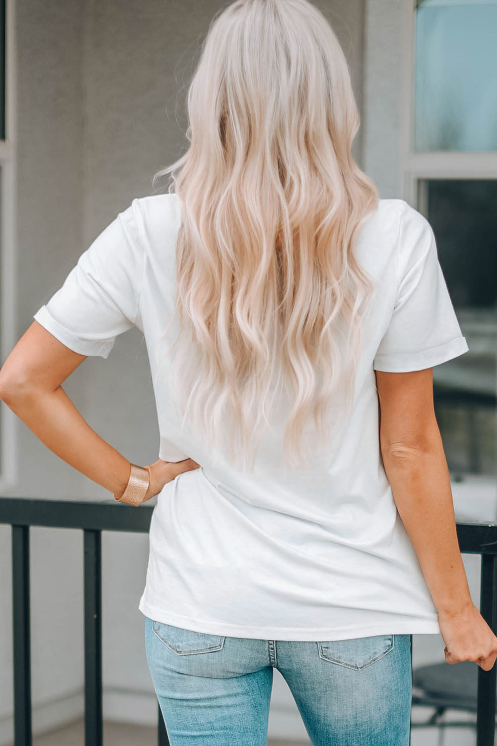White t-shirt with short sleeves and a casual fit, styled with jeans.