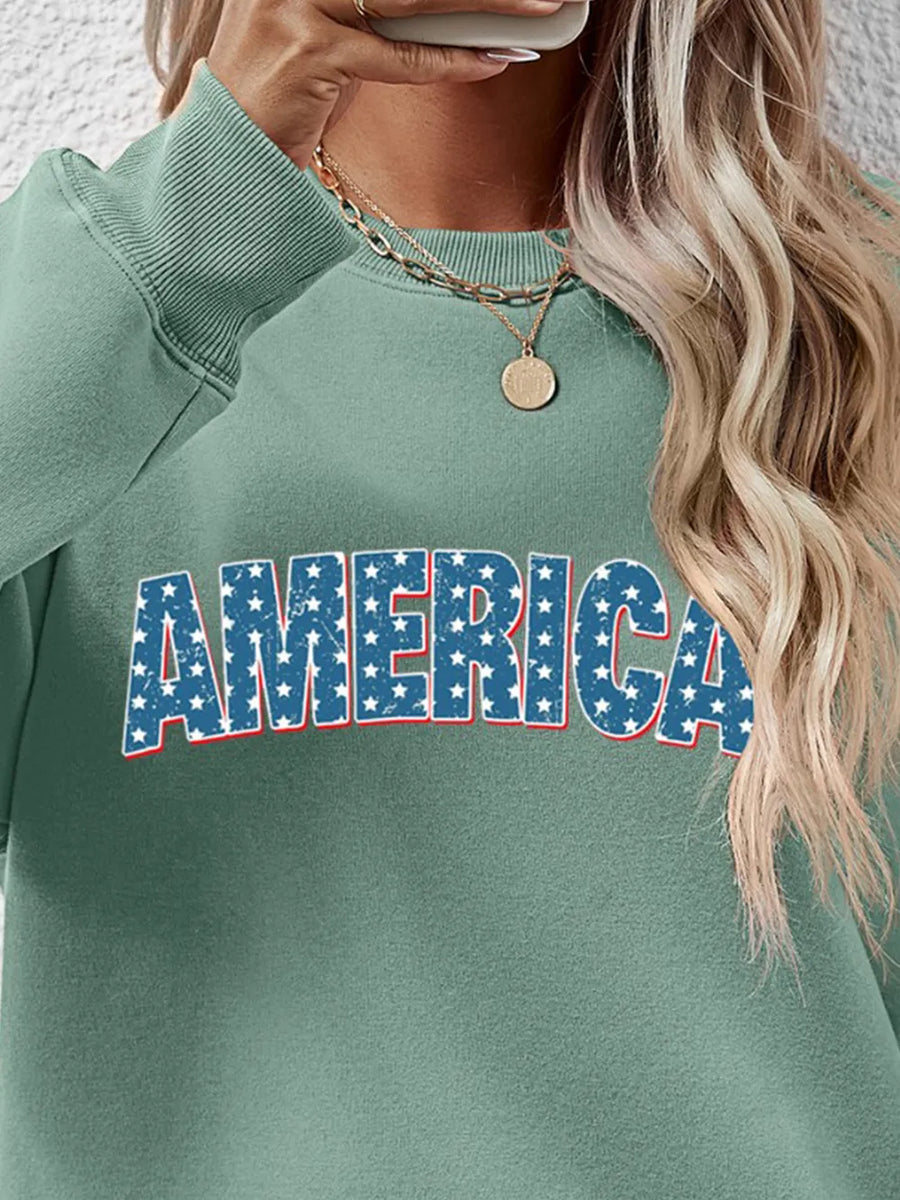 Sage green crewneck sweatshirt with distressed blue stars and white lettering spelling AMERICA