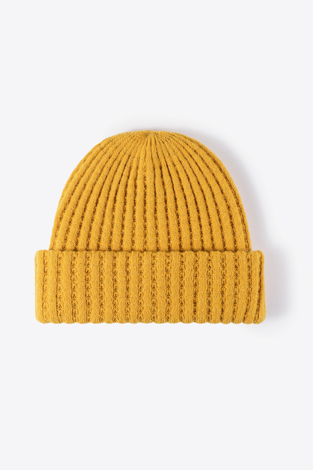 Textured ribbed knit beanie in mustard yellow acrylic with a cuffed hem.
