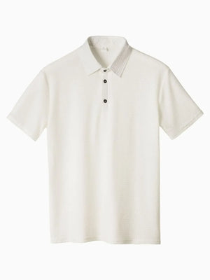White textured pique polo shirt with refined collar and dark buttons.