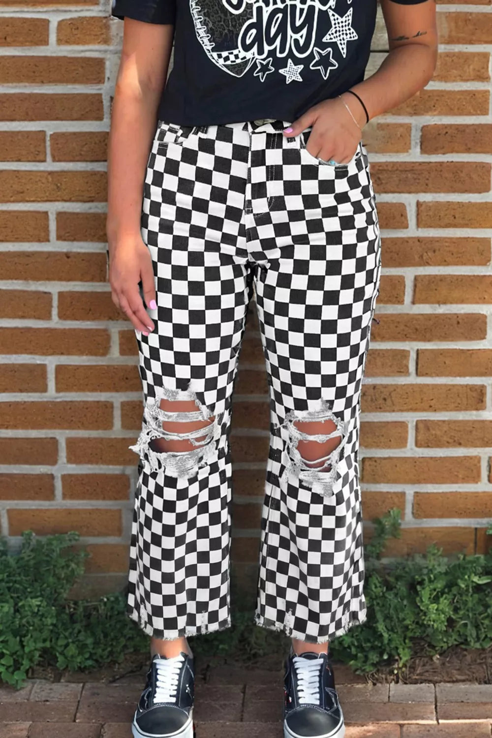 Checkerboard distressed cropped jeans with ripped knees and frayed hem.