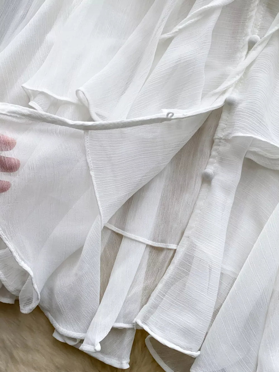 White chiffon tiered blouse with ruffled details and tie neckline.
