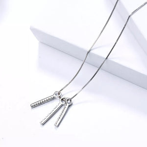 necklace in clear with geometric and tassel pendant