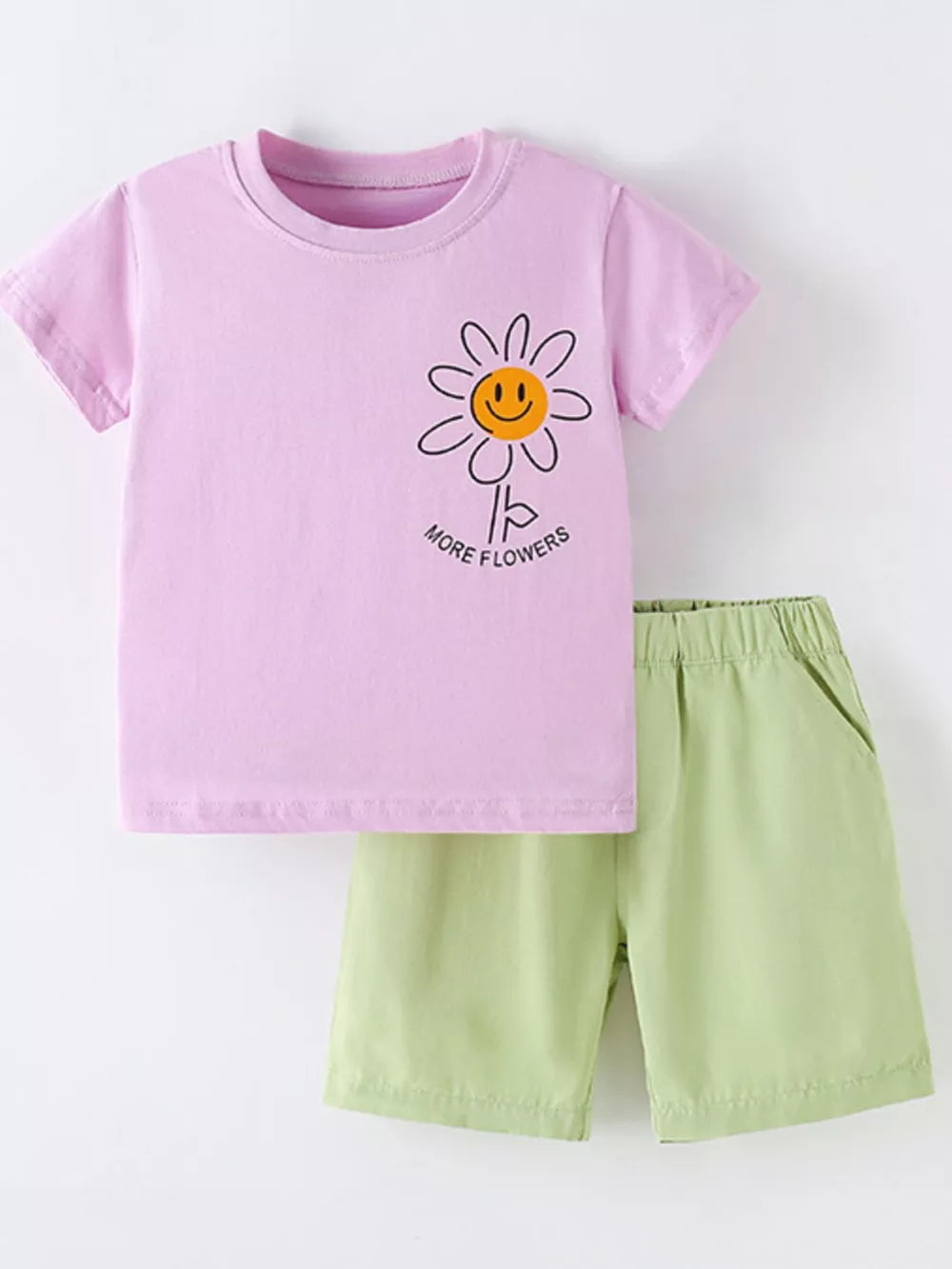 Girls' pink cotton blend tee with daisy graphic and green shorts.