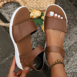 Brown adjustable platform sandals with open toe and chunky white sole.