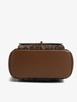 Mini backpack bag with leopard print and brown trim.