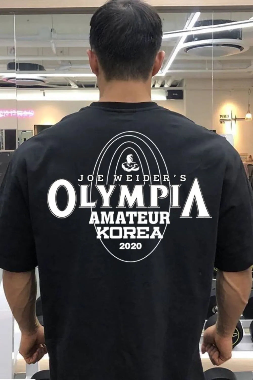 Black oversized tee with Joe Weider's Olympia Amateur Korea 2020 graphic print.