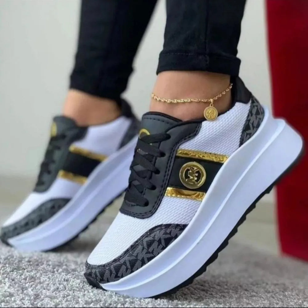 Chic round toe platform sneakers in black and white with gold accents and logo detail.