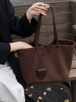 Large caramel brown suede tote bag with leather detail and braided strap detail.