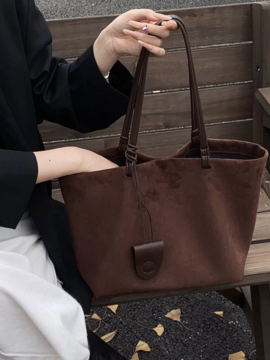 Large caramel brown suede tote bag with leather detail and braided strap detail.