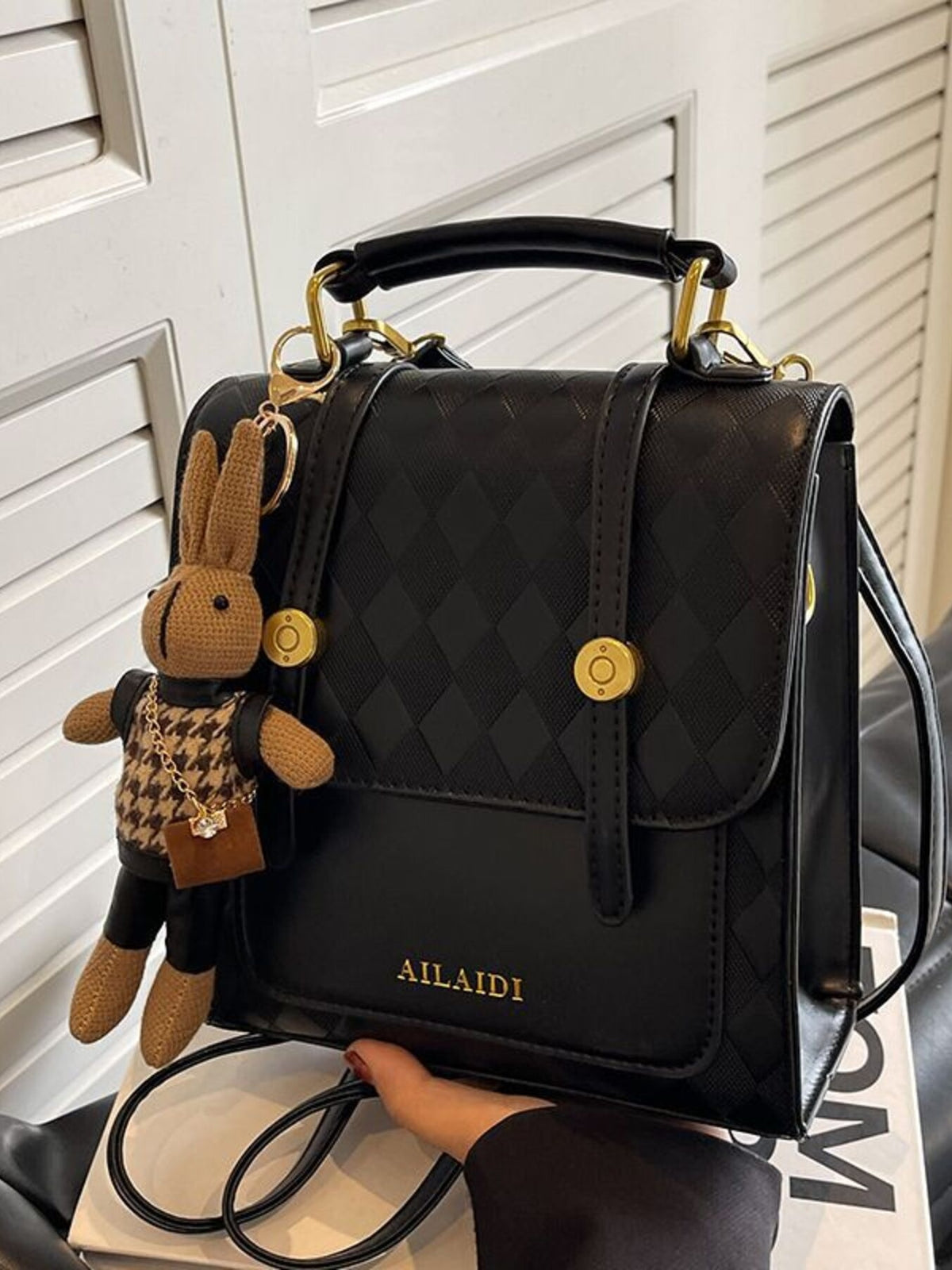Black quilted flap backpack with bunny charm and gold hardware