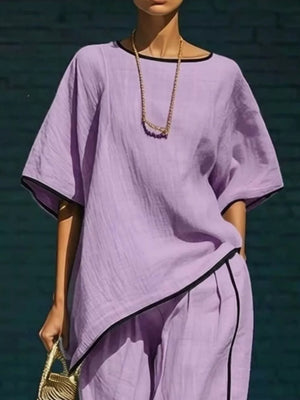 Purple two-piece set with contrast trim, cropped pants and short sleeves.