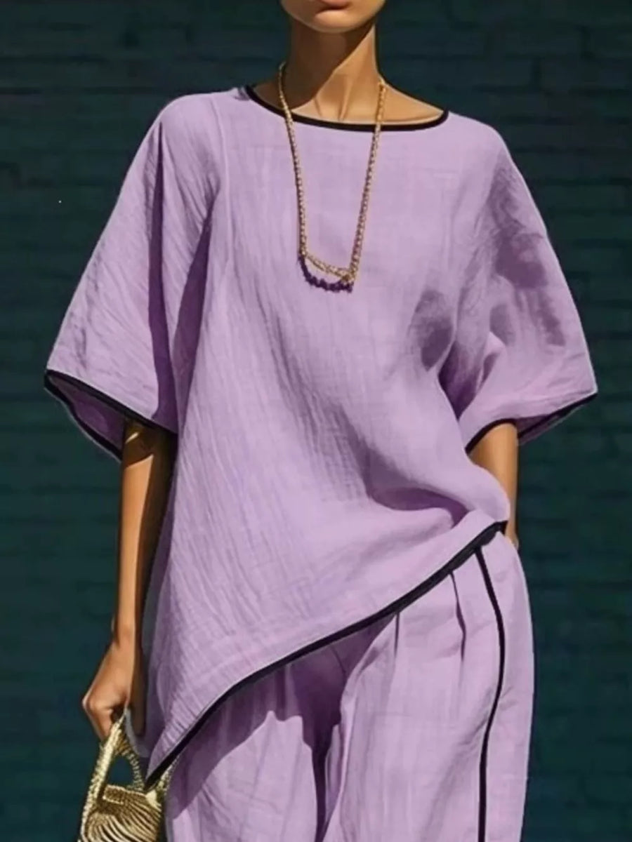Purple two-piece set with contrast trim, cropped pants and short sleeves.