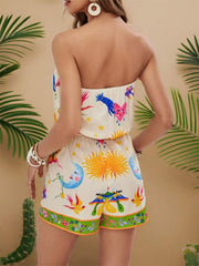 Print strapless ruched romper in multicolor with sun, moon, and bird graphics.