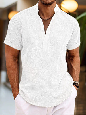 Men's white short sleeve cotton blend henley shirt with buttoned placket and mandarin collar.