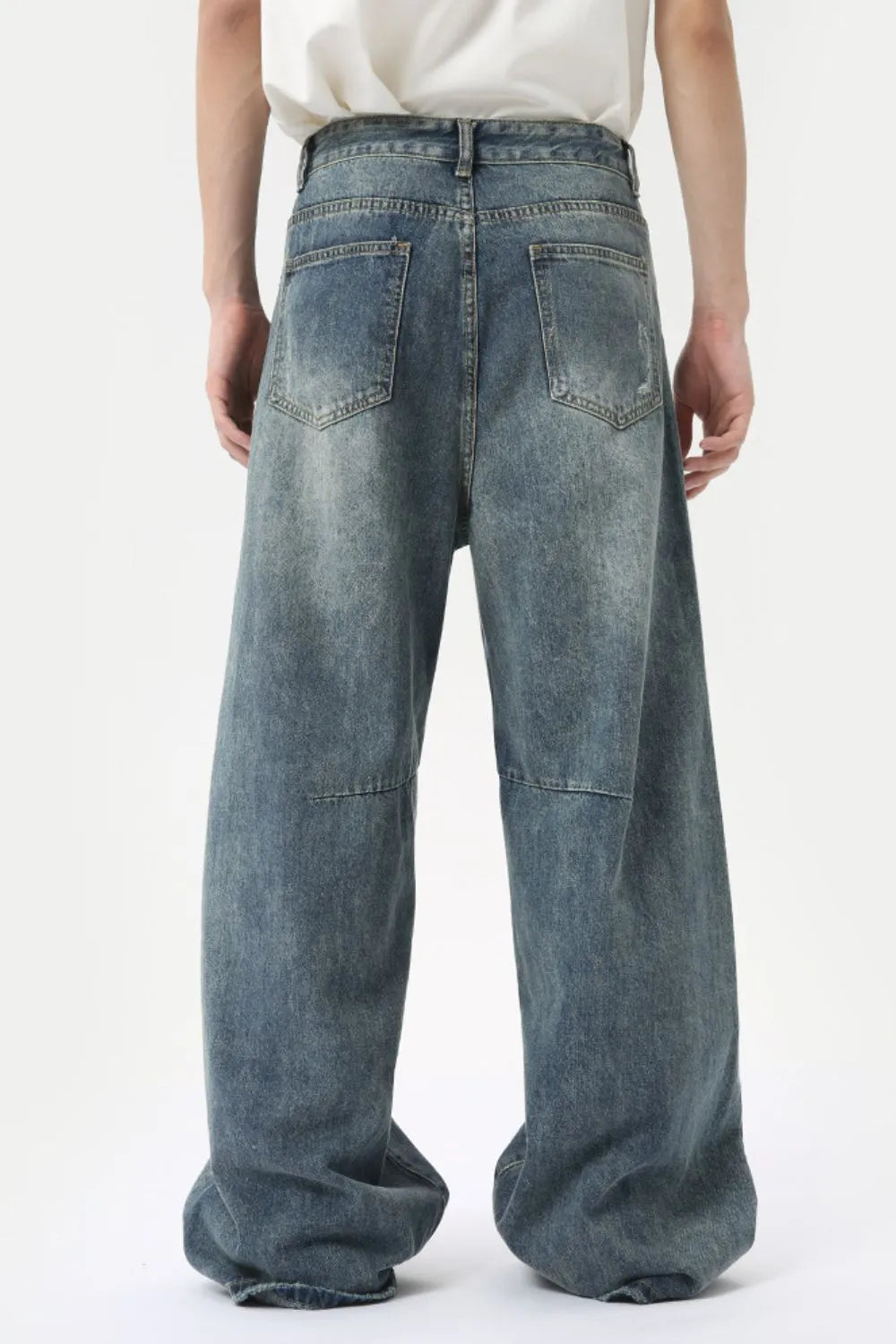 Oversized patchwork distressed denim trousers in medium wash, featuring a baggy fit and wide leg.