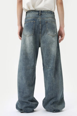 Oversized patchwork distressed denim trousers in medium wash, featuring a baggy fit and wide leg.