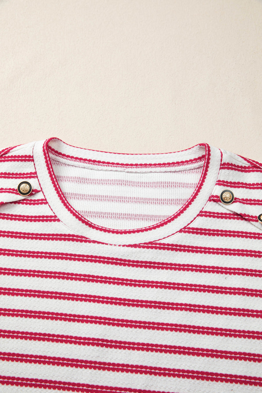 Textured knit tee with red stripes, crew neck, and decorative button detail.