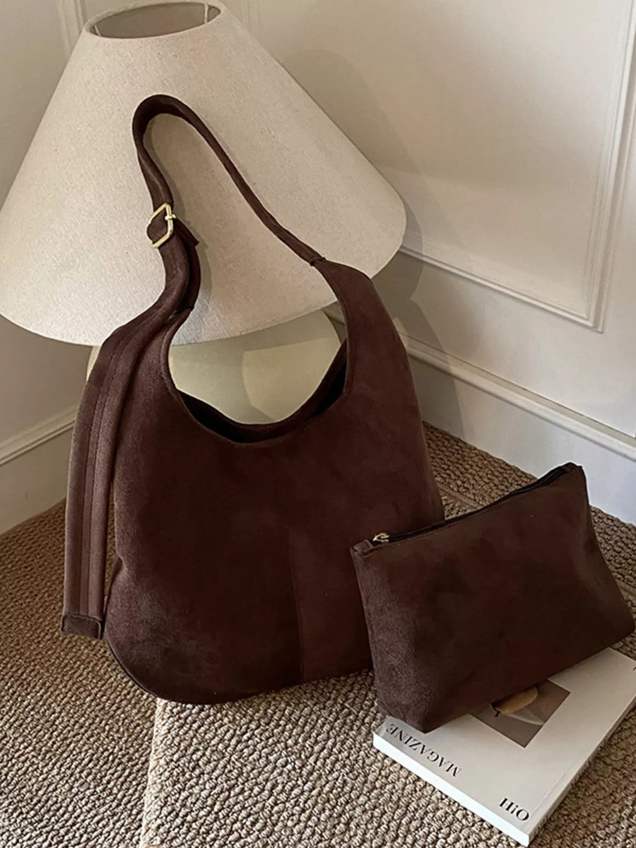 Brown suede hobo shoulder bag with adjustable strap and matching pouch.