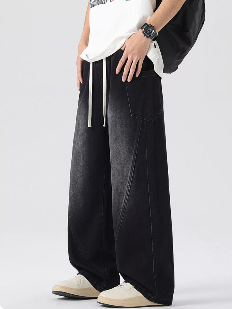 Oversized wide-leg jeans in smoky gray denim with drawstring waist and vintage wash.