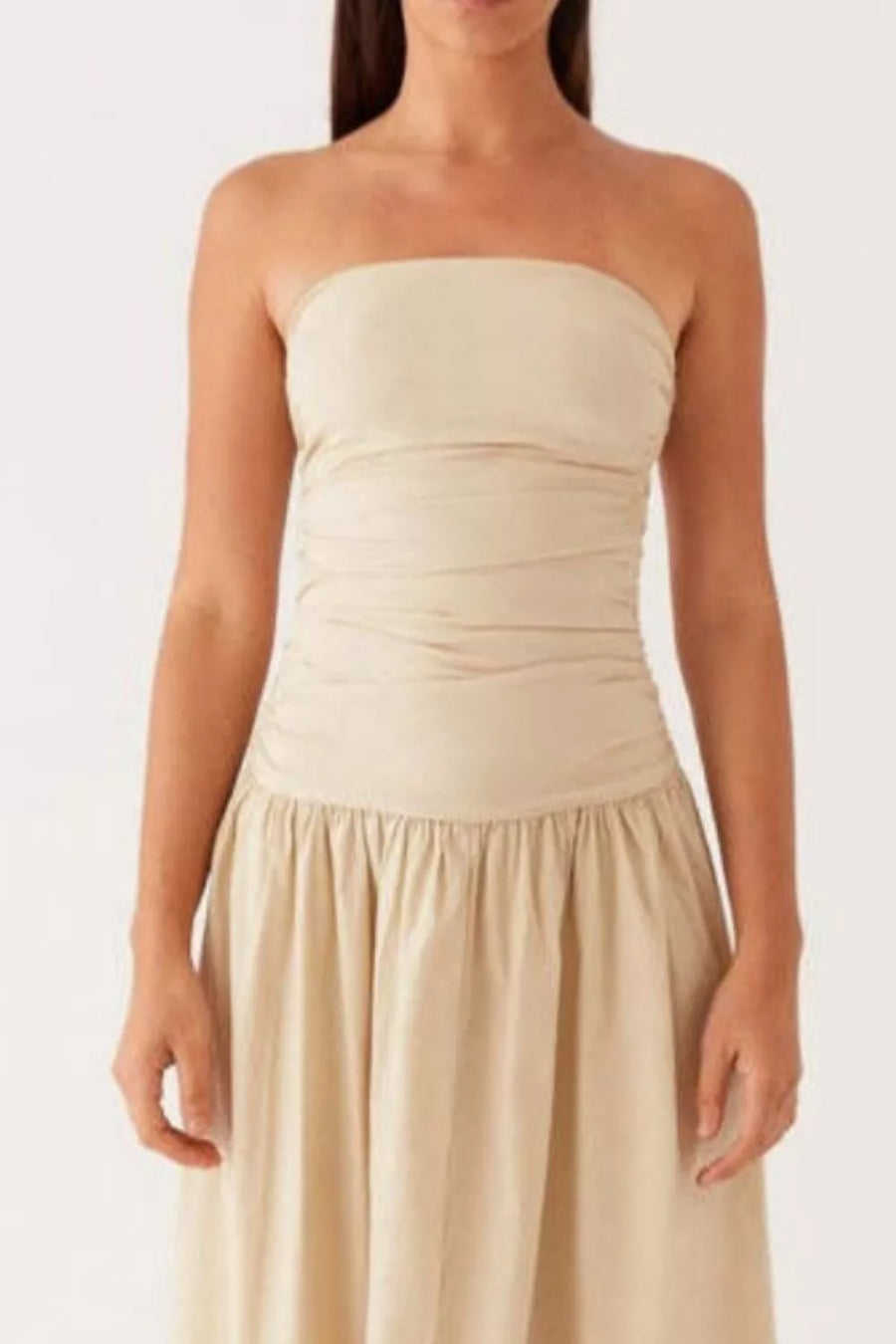 Cream ruched strapless maxi dress with a flowing skirt