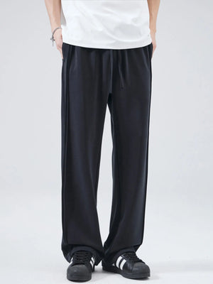 Black relaxed fit drawstring casual pants with side seam detail.