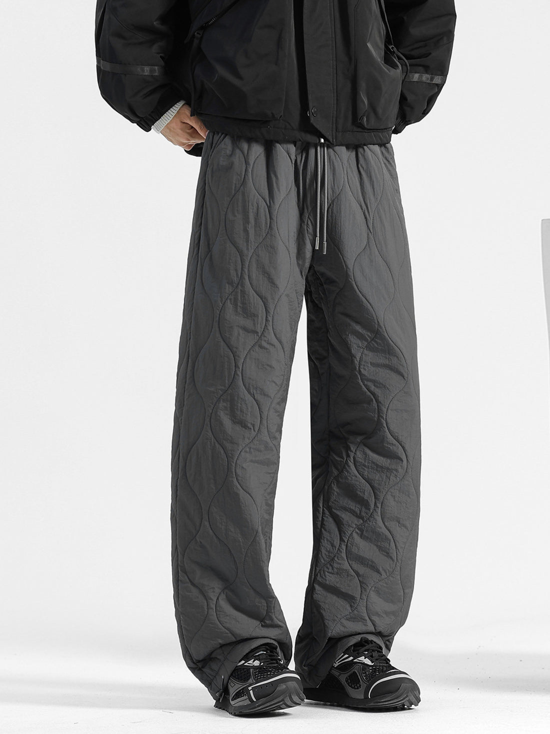 Men's dark gray quilted sweatpants with a relaxed fit and drawstring waist.