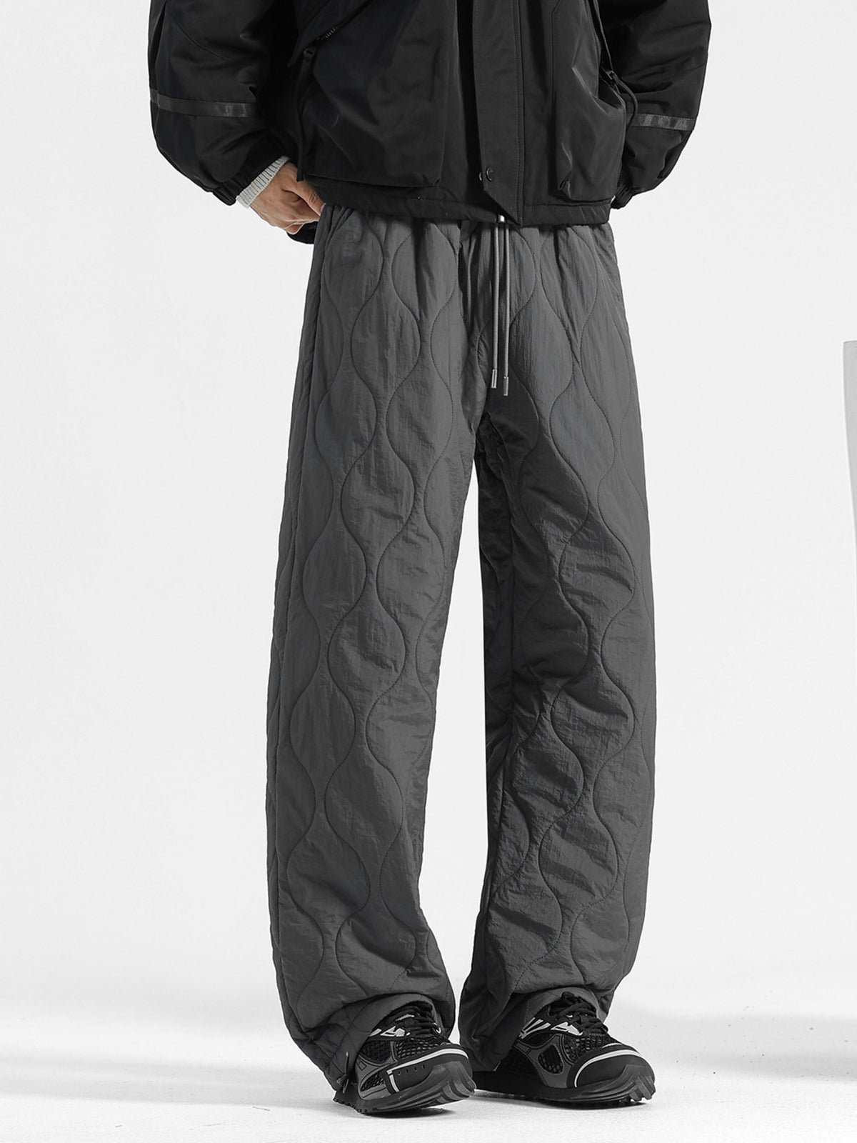 Men's dark gray quilted sweatpants with a relaxed fit and drawstring waist.