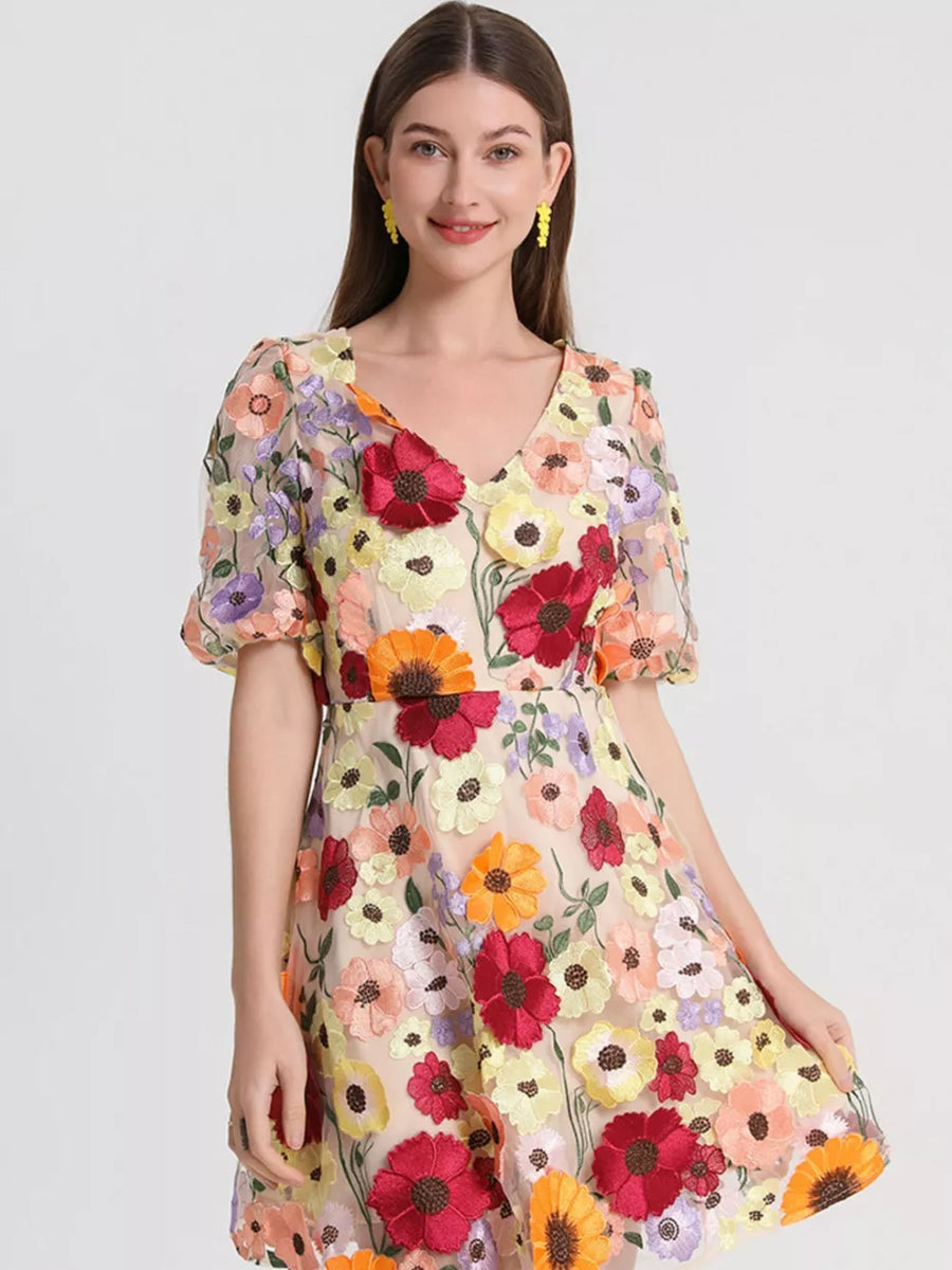 Sheer floral embroidered dress with V-neck and puff sleeves.