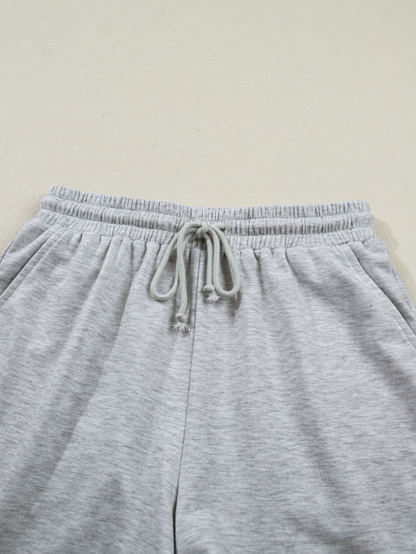 Grey polyester lounge pants with drawstring waist and elastic waistband.