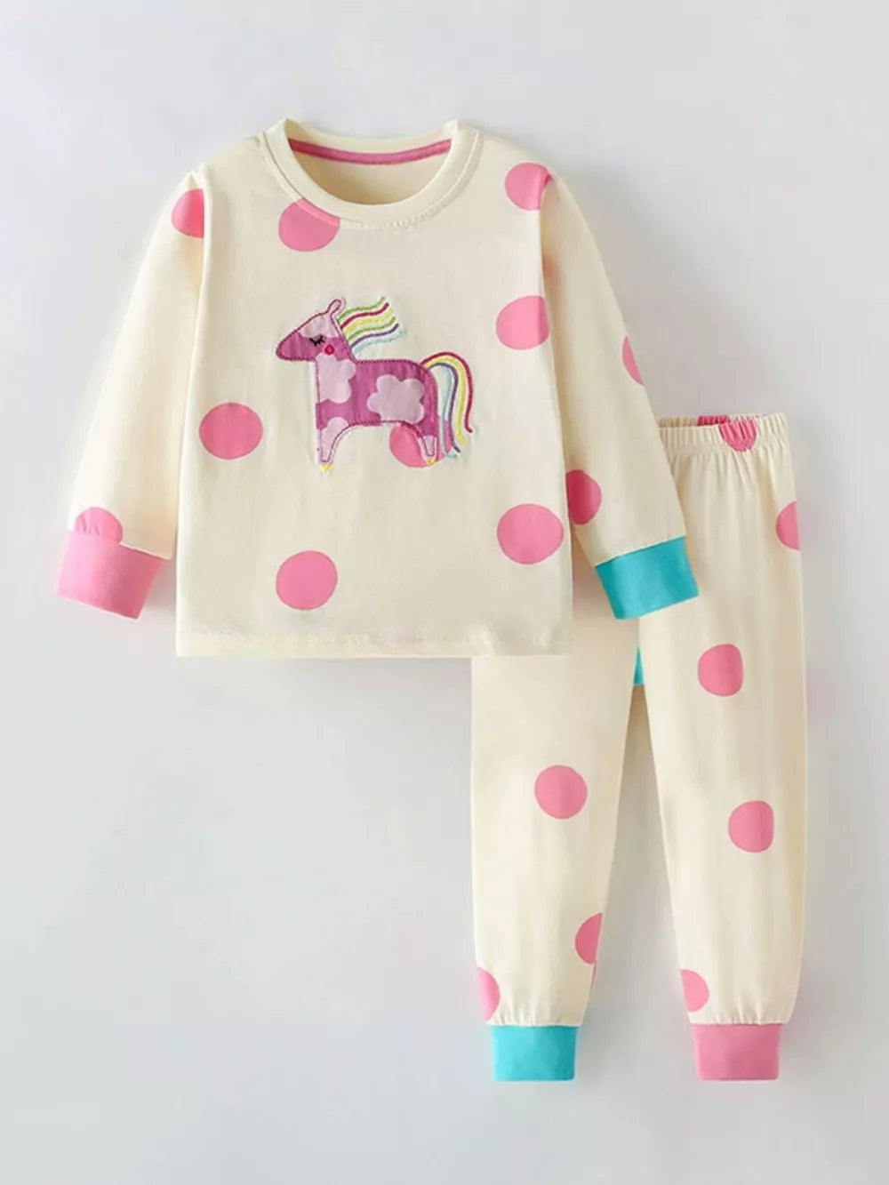 Toddler cream cotton pajama set with pink polka dots and unicorn applique.
