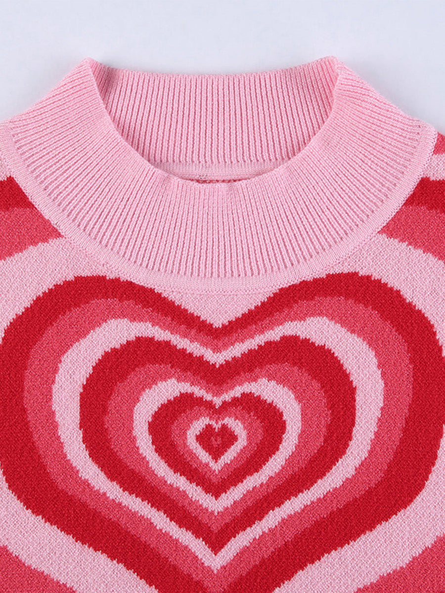 Pink knit tank top with concentric heart intarsia pattern in shades of red and pink.
