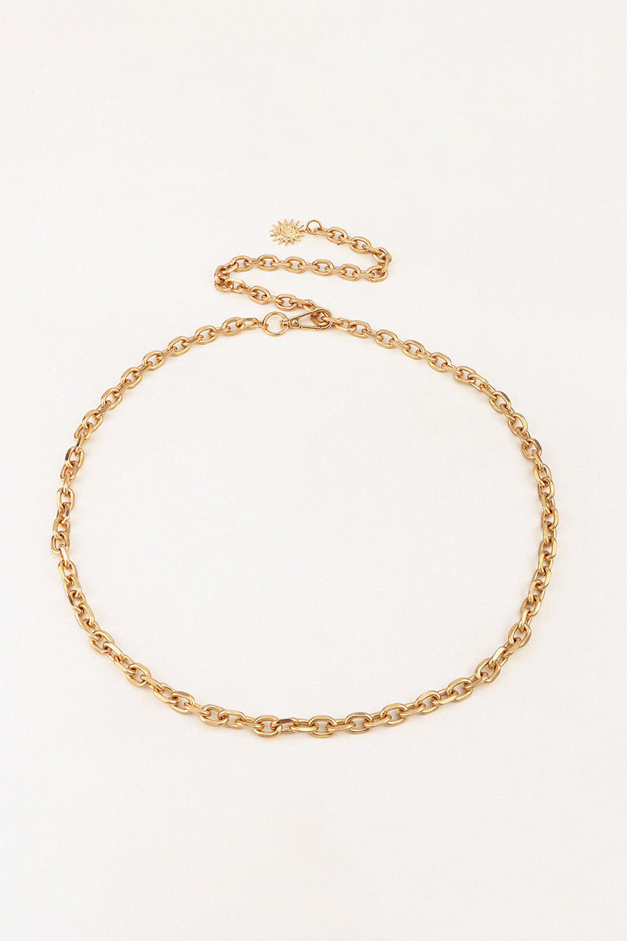 Gold chain waist belt with sunburst charm and lobster clasp closure.