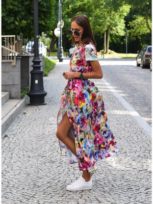 Maxi dress with a vibrant floral print, V-neck, short sleeves, and a high slit.