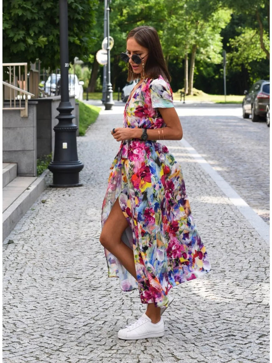 Maxi dress with a vibrant floral print, V-neck, short sleeves, and a high slit.